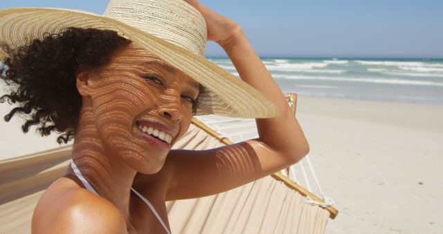 A joyful African American woman smiles at the beach, embodying relaxation and happiness. - Download Free Stock Photos Pikwizard.com