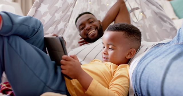 Father and Son Relaxing with Digital Tablet in Cozy Blanket Fort - Download Free Stock Images Pikwizard.com