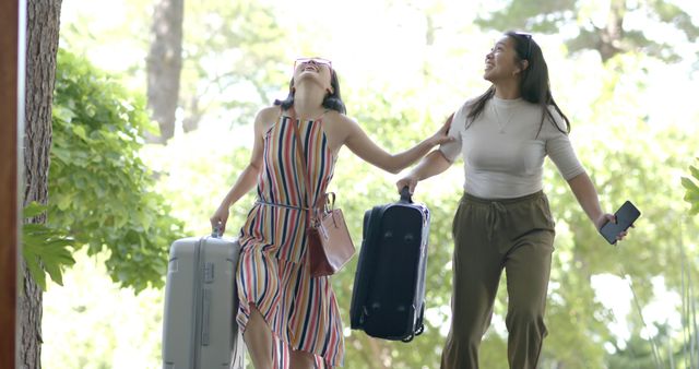 Two Women Joyfully Arriving with Luggage in Outdoorsy Location - Download Free Stock Images Pikwizard.com