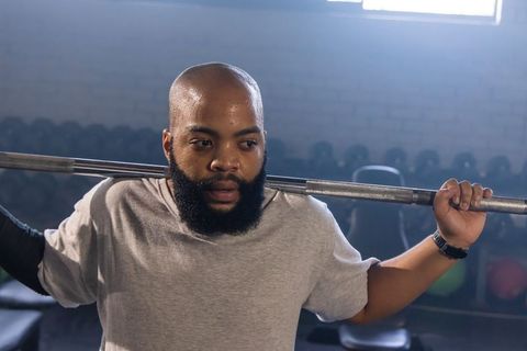 African american man lifting barbell sweating during intense strength training session
