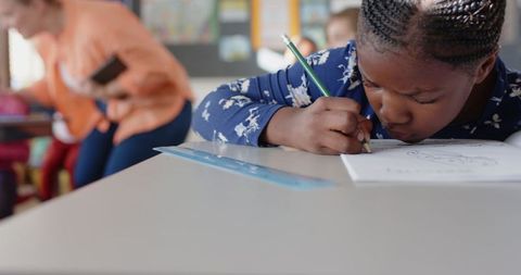 Focused Girl Writing in School with Pencil