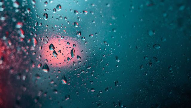 Raindrops on Glass with Blurred Lights Creating Dreamlike Effect