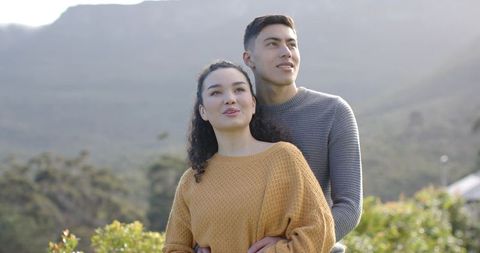 Diverse Couple Gazing at Cloudy Sky on Serene Hillside