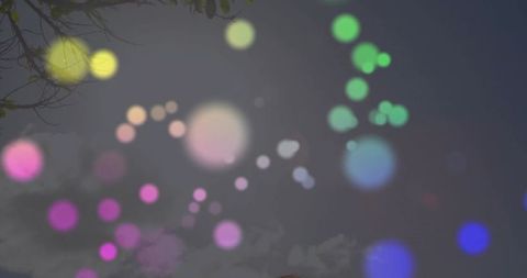 Floating translucent light orbs against cloudy sky