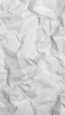 Vertical video shifting camera over crumpled white paper texture, studio close-up loop