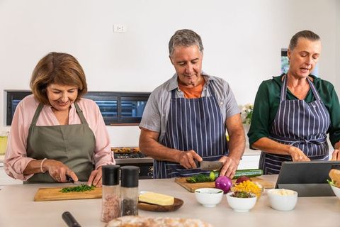 Senior Friends Enjoy Cooking Together in Modern Kitchen
