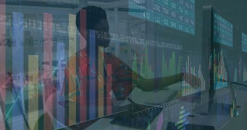 Data analyst working with digital charts on monitors in office