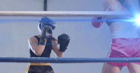 Female Boxers Sparring in Ring with Headgear and Pink Shorts, High-Intensity Training