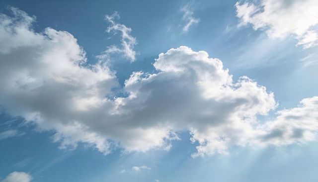 Sunlit Cumulus Cloud Drifting Over Blue Sky with Crepuscular Rays and Cirrus Streaks
