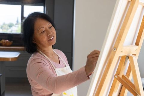 Senior Woman Engaging in Art at Home on Wooden Easel