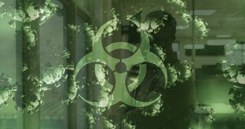 Standing man in clinic corridor showing biohazard symbol and floating virus particles