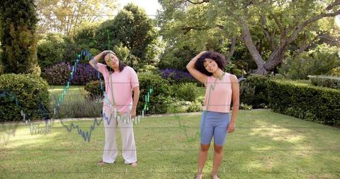 Two women stretching necks in sunlit garden with financial chart overlay, wellness concept