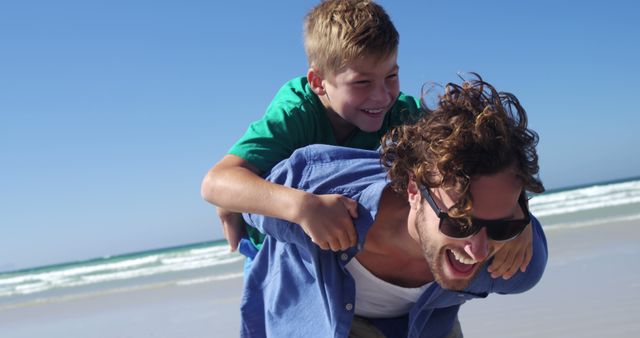 Father Giving Son Piggyback Ride on Sunny Beach - Download Free Stock Images Pikwizard.com