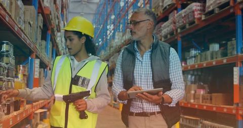 Warehouse team scanning inventory with hi-vis picker using scanner and supervisor with tablet