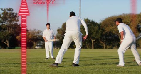 Cricket players sprinting on sunlit field wearing white kits with red data overlay