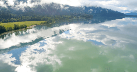 serene reflection of clouded sky on tranquil mountain lake - Download Free Stock Videos Pikwizard.com