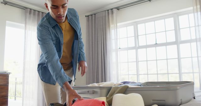 Man Packing for Vacation in Bright Room - Download Free Stock Images Pikwizard.com