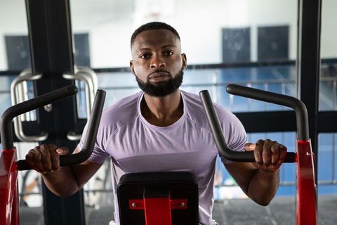 Focused African American Man Exercising on Chest Press Machine