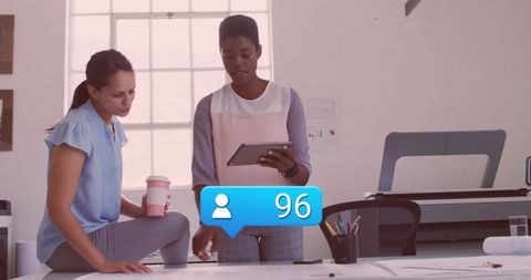 Designers Collaborating on Blueprints with Social Media Engagement