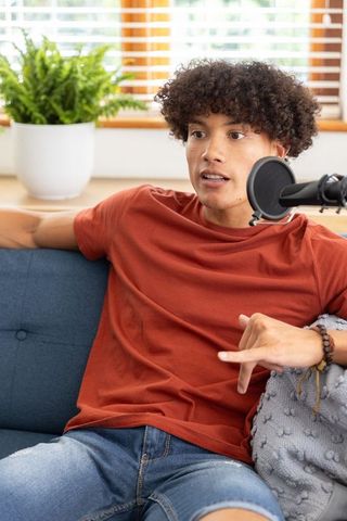 Podcaster communicating in home studio with cozy living room vibe