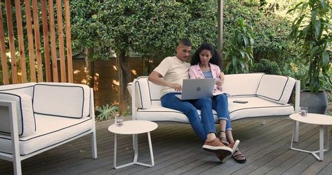 Couple Relaxing with Laptop on Outdoor Patio