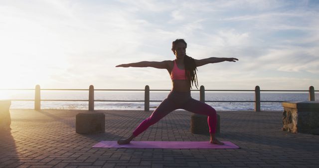 Woman practicing yoga on a mat near ocean at sunset. Perfect for fitness and wellness promotions, outdoor activity advertisements, exercise guides, and serene lifestyle illustrations.