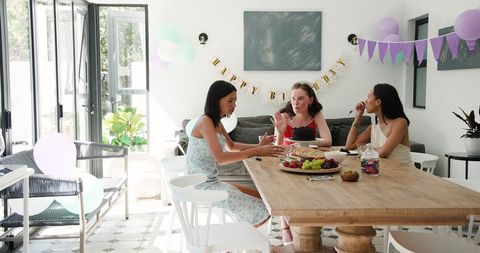 Diverse friends enjoying birthday celebration in bright dining room
