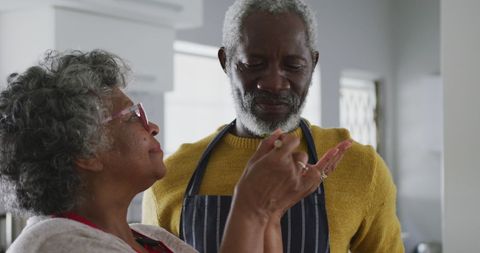 Elderly couple enjoying cooking together in modern kitchen
