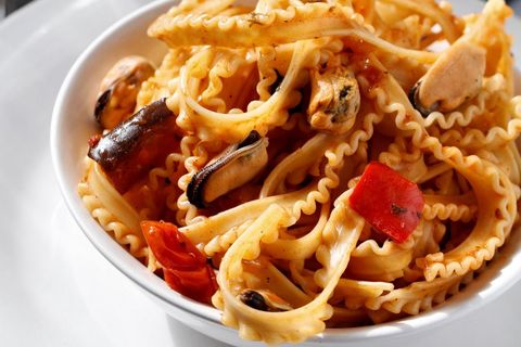 Serving seafood mafaldine pasta with mussels, roasted red peppers and tomato-herb sauce