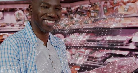 Smiling shopper choosing packaged meat with digital data overlay and pricing info in store case
