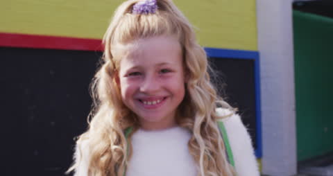 Cheerful Schoolgirl Smiling on Colorful Playground