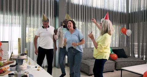 Diverse colleagues celebrating office party with joyful dance and confetti