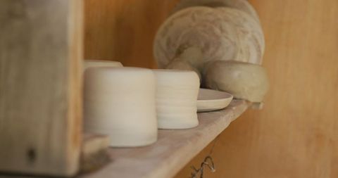 Handcrafted pottery on shelf in artisan workshop