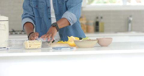 African american man preparing healthy meal on bright modern kitchen island with vegetables
