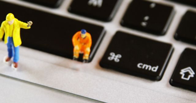 This image depicts miniature construction worker figures on a computer keyboard. Perfect for illustrating concepts of technology development, digital innovation, or the intersection of manual labor and modern technology. Ideal for articles, presentations, tech blogs, or marketing materials on advancements in the tech industry or creative visualization.