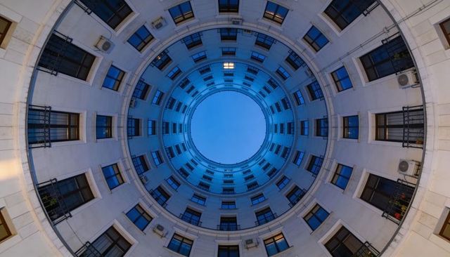 Concentric Courtyard Oculus at Blue Hour, Spiral Inner Facade with Windows and Balconies
