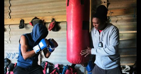 Young Boxer Training with Coach in Fitness Warehouse