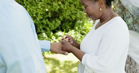 Senior Couple Exchanging Rings at Romantic Garden Wedding Ceremony