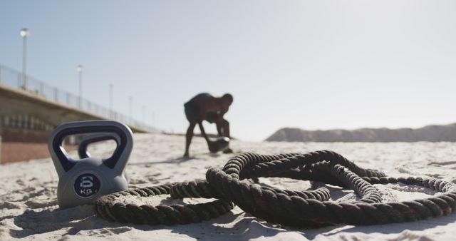 Person Exercising with Kettlebell and Battle Rope on Beach - Download Free Stock Images Pikwizard.com