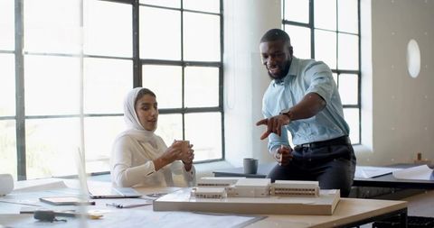 Architects collaborating over scale model at design studio table