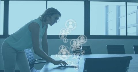 Businesswoman Connecting on Laptop with Digital Icons Overlay