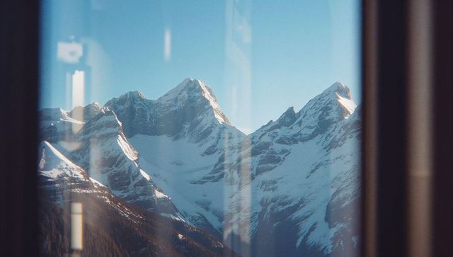 Serene Snow-Capped Mountains Viewed Through Cabin Window