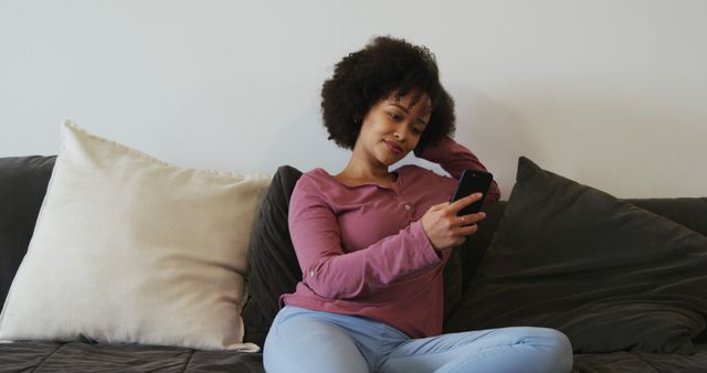 Relaxed African American Woman Using Smartphone on Comfortable Couch - Download Free Stock Images Pikwizard.com