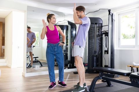 Friends Celebrating Fitness Achievement in Home Gym