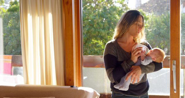 Mother Comforting Newborn Baby by Window in Sunlit Room - Download Free Stock Images Pikwizard.com