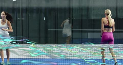 Running female tennis players training on indoor glass court with motion overlays