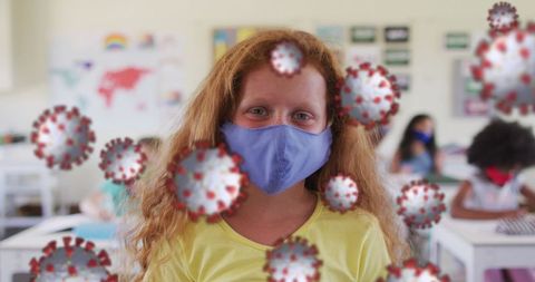 Schoolgirl with face mask and covid-19 virus symbols in classroom
