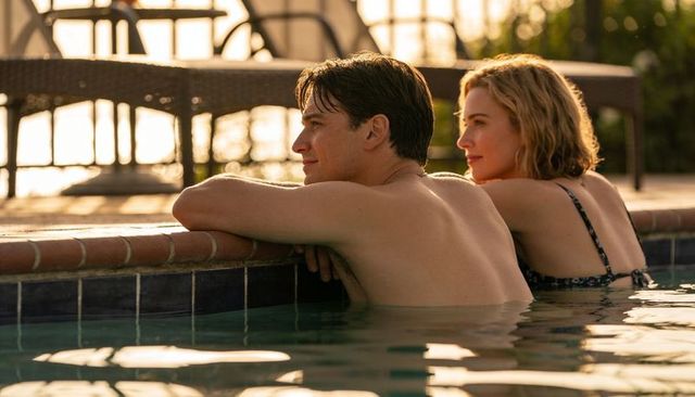 Couple relaxing in pool at golden hour leaning on tiled edge romantic backyard swim