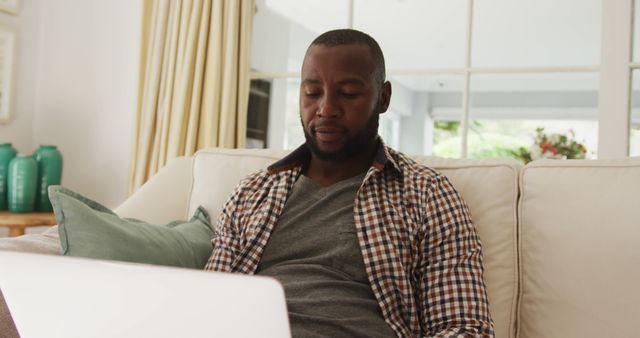 Man Relaxing on Sofa Using Laptop in Modern Living Room - Download Free Stock Images Pikwizard.com