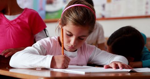 Focused Elementary School Girl Coloring in Classroom - Download Free Stock Images Pikwizard.com
